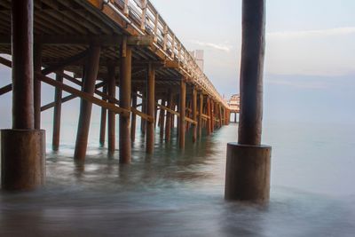 Wooden pier on sea against sky