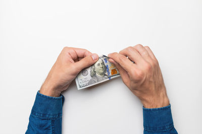 Men's hands are tearing money. hands tearing a hundred dollar bill on a white background