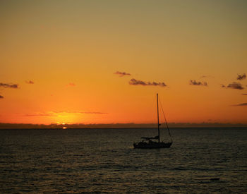 Silhouette sailboats in sea against romantic sky at sunset