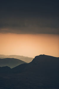 Scenic view of silhouette mountains against sky during sunset