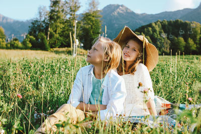 Siblings sitting on field