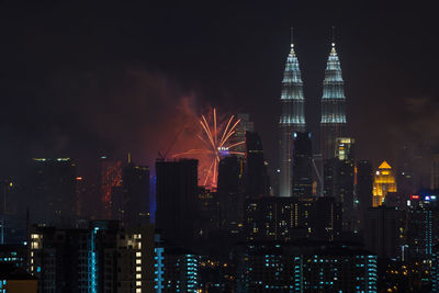 Illuminated petronas towers and fireworks at night