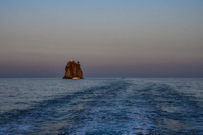 Scenic view of sea against clear sky at dusk