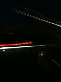 Light trails on road against sky at night