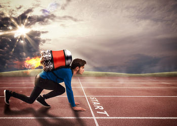 Rear view of man running on road against cloudy sky