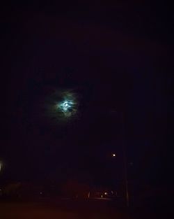 Low angle view of illuminated lights against sky at night
