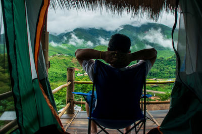 Rear view of man sitting on chair