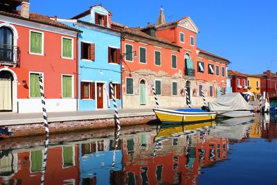 Boats moored in canal against clear sky