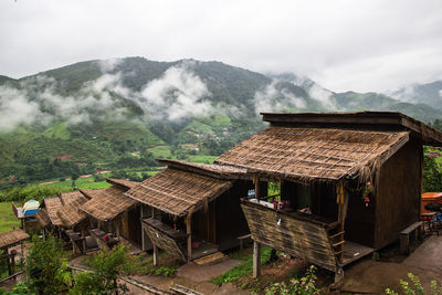Scenic view of houses by mountains against sky