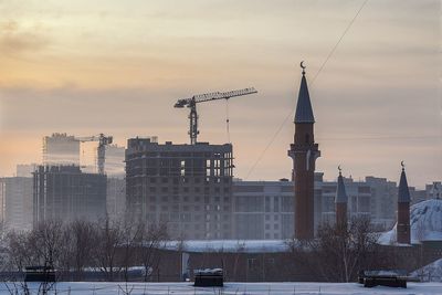 Buildings in city against sky during sunset