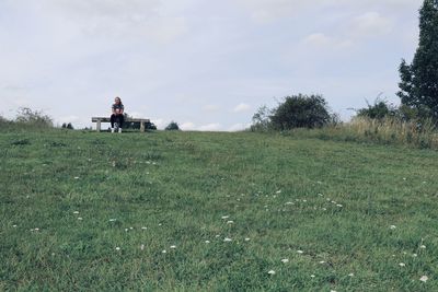 People riding on field against sky