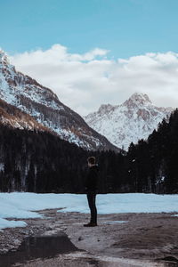 Man standing on snowcapped mountain against sky