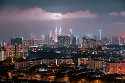 Illuminated cityscape against sky at night