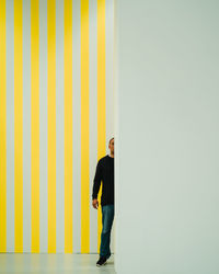 Side view of man standing against wall