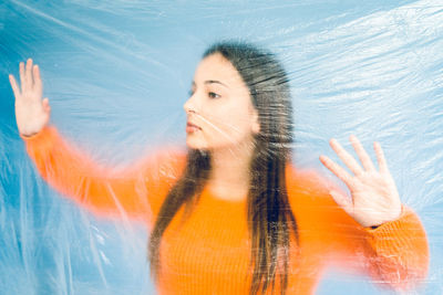 Thoughtful teenage girl trapped in plastic