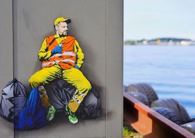 Man sitting on boat against sea