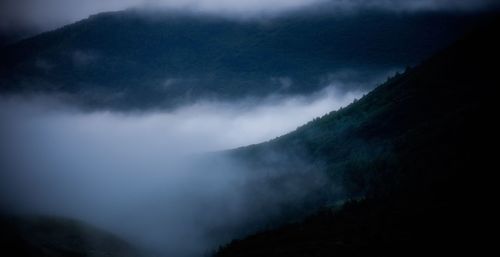 Scenic view of mountains against cloudy sky