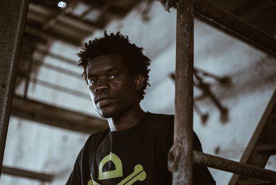 Portrait of young man looking away while standing in building