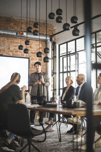 Male hacker discussing business ideas with investors in office