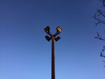 Low angle view of road sign against clear blue sky