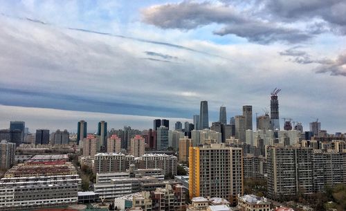 View of cityscape against cloudy sky