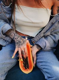 Midsection of woman holding papaya