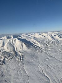 Scenic view of snowcapped mountains against clear blue sky