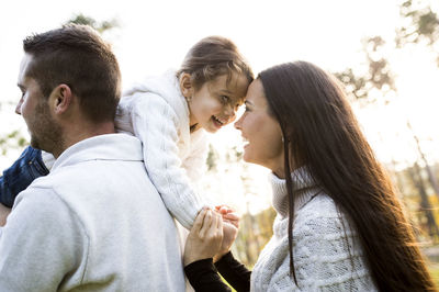 Happy parents with girl outdoors