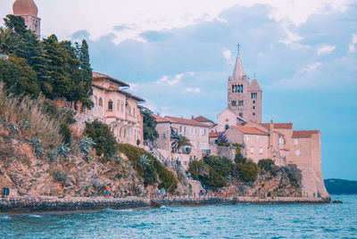 Panoramic view of sea and buildings against sky