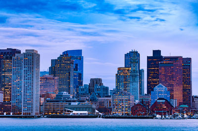 Buildings in city against cloudy sky