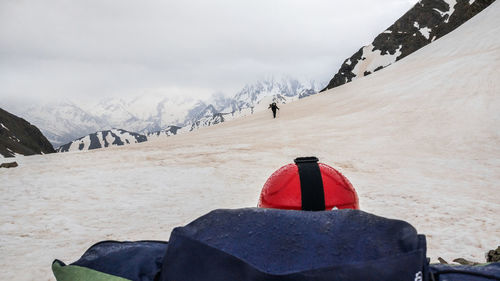 Red umbrella on snowcapped mountain against sky