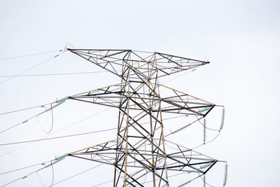 Low angle view of electricity pylon against clear sky