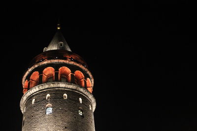 Low angle view of illuminated building against sky at night