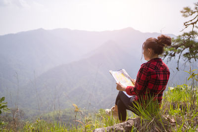 Rear view of woman standing on mountain
