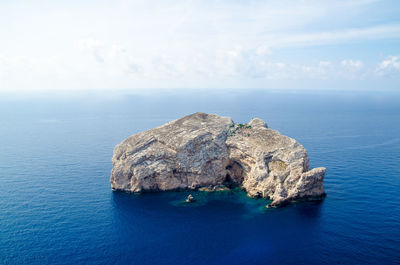 Rock formations in sea against sky