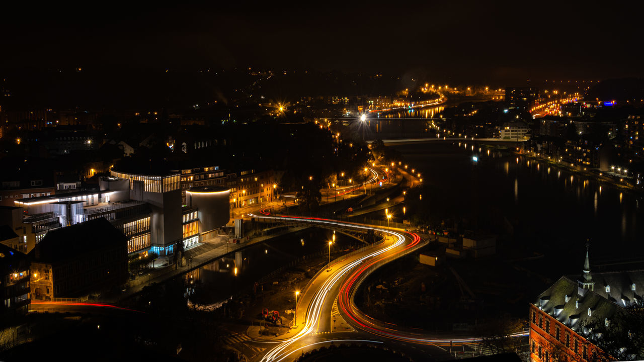 illuminated, night, city, architecture, building exterior, built structure, cityscape, high angle view, long exposure, motion, transportation, road, light trail, no people, city life, glowing, street, speed, residential district, outdoors