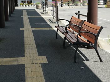 Empty bench on road in city