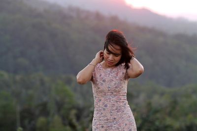 Mid adult woman wearing dress while standing on mountain