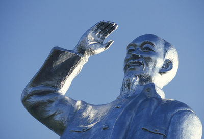 Low angle view of ho chi minh statue against clear blue sky