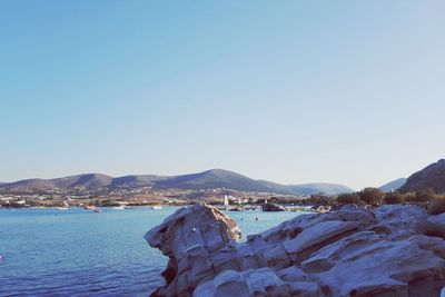 Scenic view of sea and mountains against clear blue sky