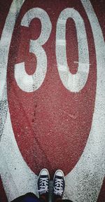 Low section of person standing on road sign