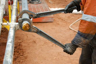 Midsection of worker working on field