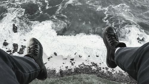 Low section of man standing on beach