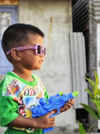 Full length of boy holding toy gun