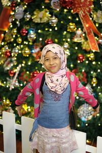 Close-up of a girl standing in front of the christmas tree