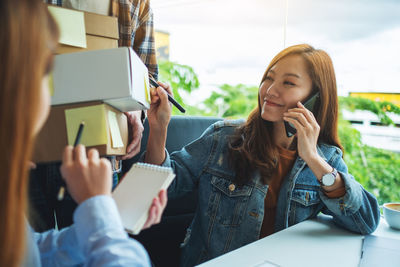 Young woman using mobile phone at office