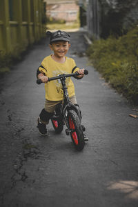 Portrait of cute 2 year old toddler riding a push bike