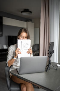 Young woman using laptop while sitting at home