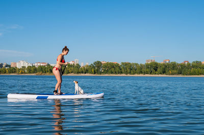 Woman with dog paddle boarding
