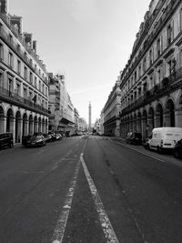 Cars on road against sky in city
